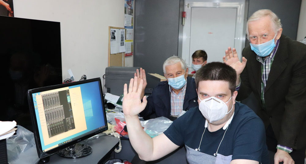 4 men in office waving at camera