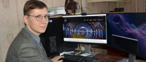Man sitting at a desk with a computer screen showing